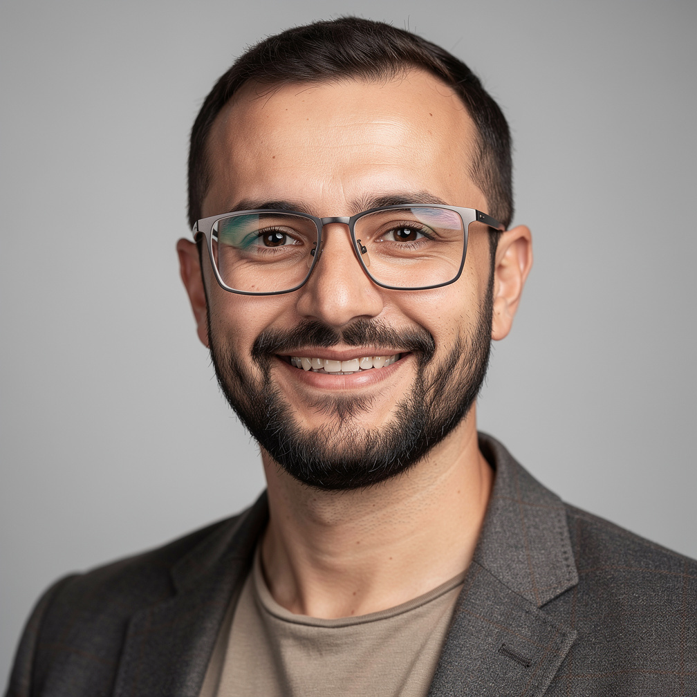 Turkish male journalist with beard and glasses smiling